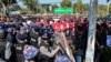 Police block protesters as they gather near a statue of General Aung San during a demonstration in Loikaw, Myanmar, Feb. 12, 2019.