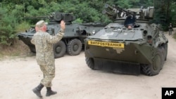 FILE - Ukrainian armored military vehicle BTR 3E takes position prior to a test firing at the shooting range of the Kiev's armored plant, in Kyiv,Ukraine.