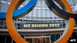 西藏活动人士在位于瑞士洛桑的国际奥委会总部大门处拉起抵制北京冬奥会的横幅。（2021年12月11日）