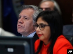 FILE - Secretary General of the Organization of American States Luis Almagro, left, listens to Venezuela's Foreign Minister Delcy Rodriguez as she speaks to the Permanent Council of the Organization of American States in Washington, March 27, 2017.