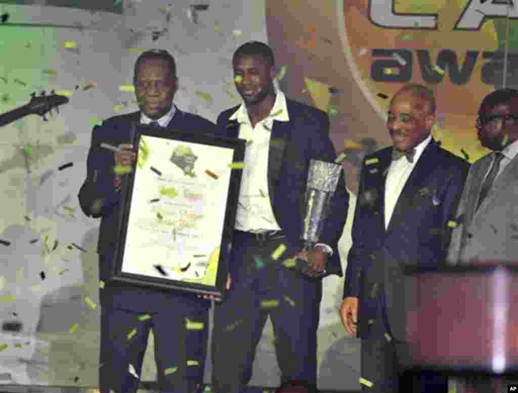 Ivory Coast midfielder Yaya Toure, second left, holds the African Player of the Year trophy he received during an award ceremony in Accra, Ghana, Thursday, Dec. 22, 2011. The Manchester City player won ahead of Mali and Barcelona midfielder Seydou Keita, 