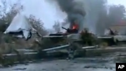 A Syrian military tank is shown as having caught fire outside Deir Ezzor in this January 29, 2013, file photo.