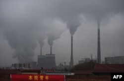 FILE - In this photo taken on Nov. 19, 2015, smoke belches from a coal-fueled power station near Datong, in China's northern Shanxi province.
