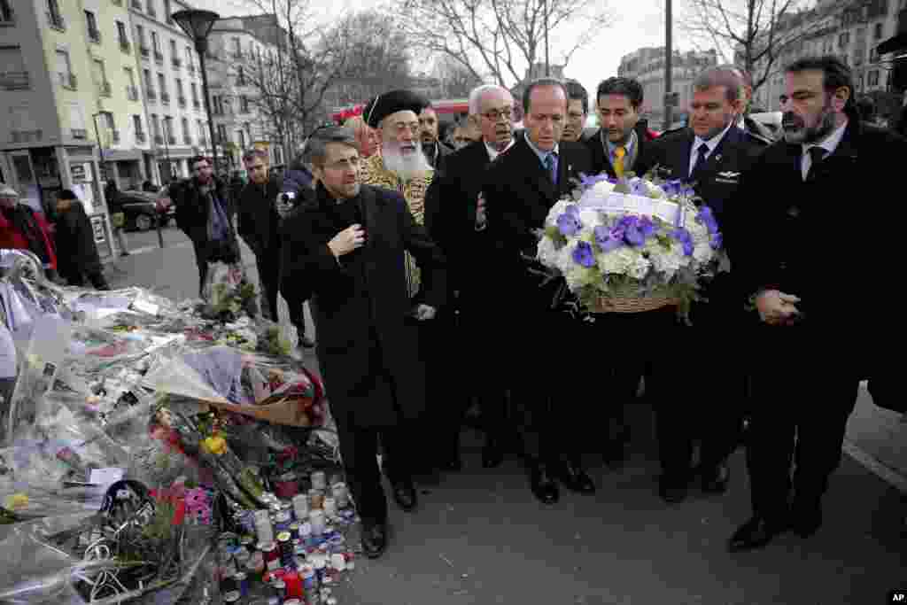 Jerusalem Mayor Nir Barkat, center, and Israeli Chief Rabbi Shlomo Amar, second left, lay a wreath of flowers at the kosher grocery where Amedy Coulibaly killed four people in a terror attack, in Paris, Wednesday, Jan. 21, 2015. 