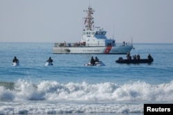 U.S. Border agents and the Coast Guard patrol the Pacific Ocean where the U.S. Mexico border wall enters the water at Border Field State Park in San Diego, Nov. 20, 2018.