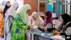 Women line up to vote at a polling station at Penanti in Penang state in northern Malaysia, May 5, 2013. 