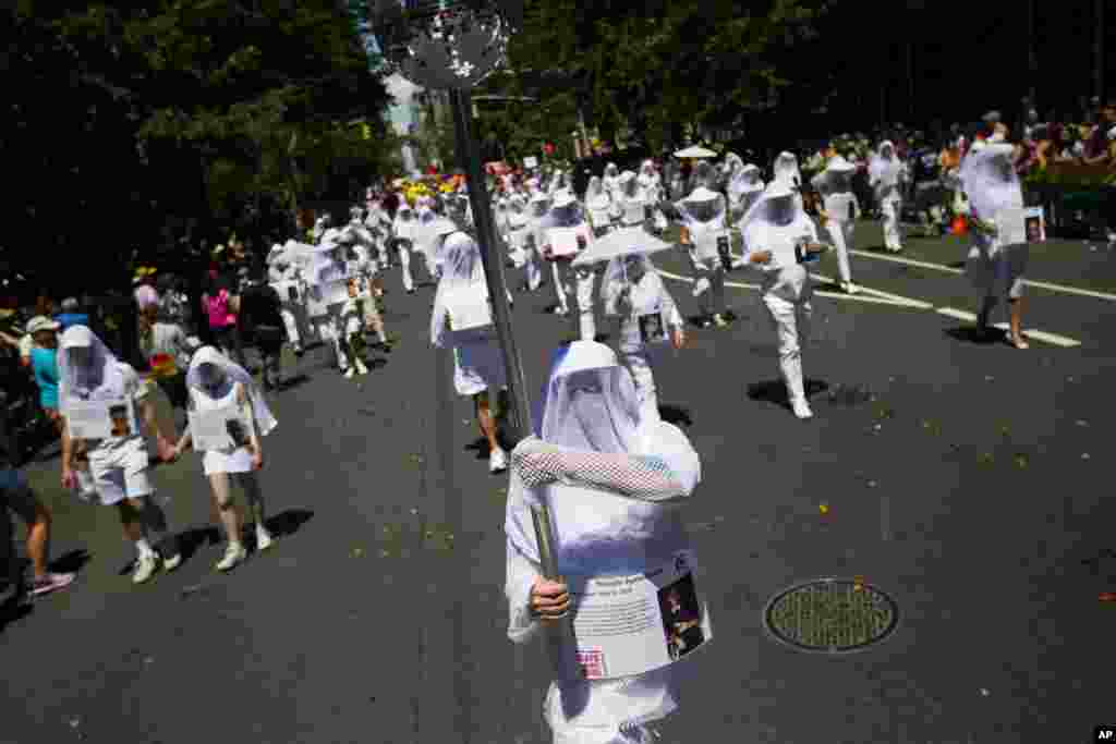 Members of Gays against Guns wear all white and signs of those killed a year ago at the Pulse Night Club in Orlando during the New York City Pride Parade, June 25, 2017.