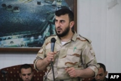 FILE - Zahran Alloush, head of the Army of Islam Syrian rebel group, speaks during the wedding of a fighter in the group in the rebel-held town of Douma, on the eastern edge of Damascus, Syria, July 21, 2015.