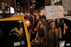 Protesters march along 57th Street toward Trump Tower, Nov. 9, 2016, in New York, in opposition of Donald Trump's presidential election victory.
