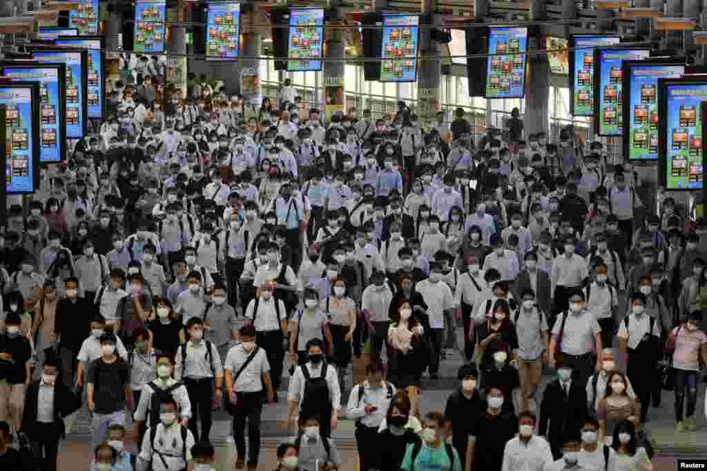 Commuters wearing face masks arrive at Shinagawa Station at the start of the working day amid the COVID-19 outbreak in Tokyo, Japan.