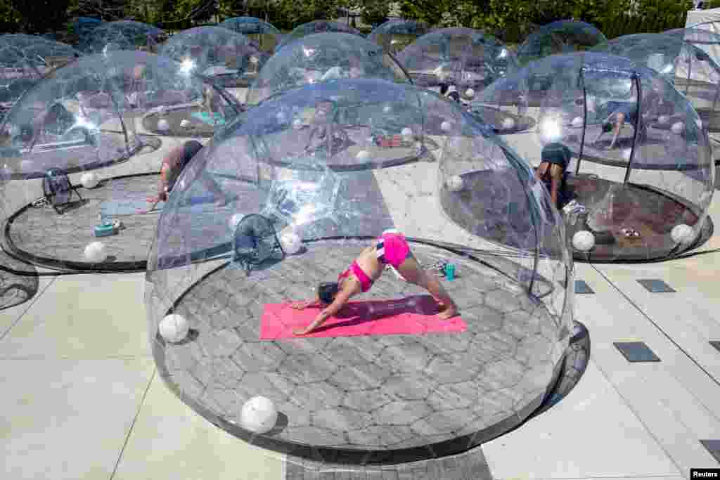 People participate in an outdoor yoga class by LMNTS Outdoor Studio, in domes in Toronto, Ontario, Canada, June 21, 2020.