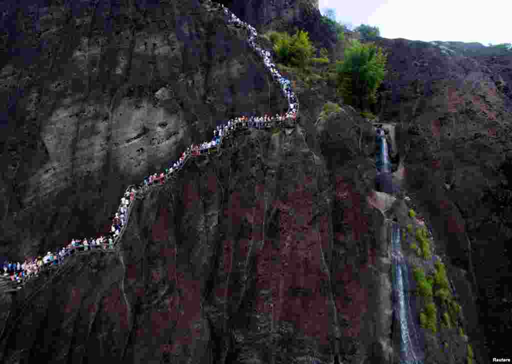 Para pengunjung berjalan mengelilingi pegunungan Wuyi, di kota Nanping, Fujian, China.