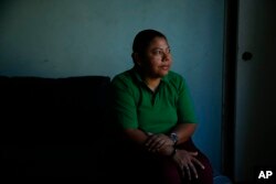 Iris Acosta, a 51-year-old hotel housekeeper from Honduras, pauses for photos in her sister's apartment in Los Angeles, Oct. 18, 2017.