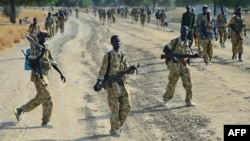 Sudan People's Liberation Army (SPLA) soldiers walk on a road inear Bor, in Jonglei state, on Jan. 31, 2014. 