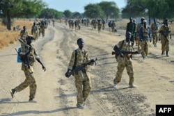 FILE - Sudan People's Liberation Army (SPLA) soldiers walk along a road in Mathiang near Bor, Jan. 31, 2014.