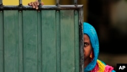 A Sri Lankan Muslim woman looks out on the street, in Aluthgama, town, 50 kilometers (31.25 miles) south of Colombo, Sri Lanka, June 16, 2014.