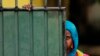 FILE - A Sri Lankan Muslim woman looks out on the street, in Aluthgama, town, 50 kilometers (31.25 miles) south of Colombo, Sri Lanka.