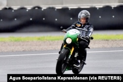 Presiden Joko Widodo mengendarai sepeda motor saat mencoba lintasan di Sirkuit Mandalika di Lombok, Nusa Tenggara Barat, 12 November 2021. (Foto: Agus Soeparto/Istana Kepresidenan via REUTERS)