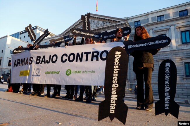 People hold placards reading "Decisions that kill" during a gathering to demand a halt of arms sales to Saudi Arabia, outside Parliament in Madrid, Spain, Oct. 24, 2018.