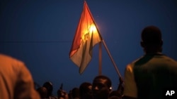 21일 부르키나파소 수도 와가두구에서 시위대가 국기를 들고 군부 쿠데타에 항의하고 있다.