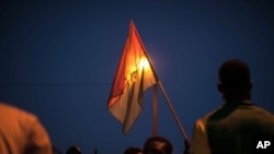 A protestor holds a Burkina Faso national flag during a protest against a recent coup in Ouagadougou, Burkina Faso, Sept. 21, 2015..