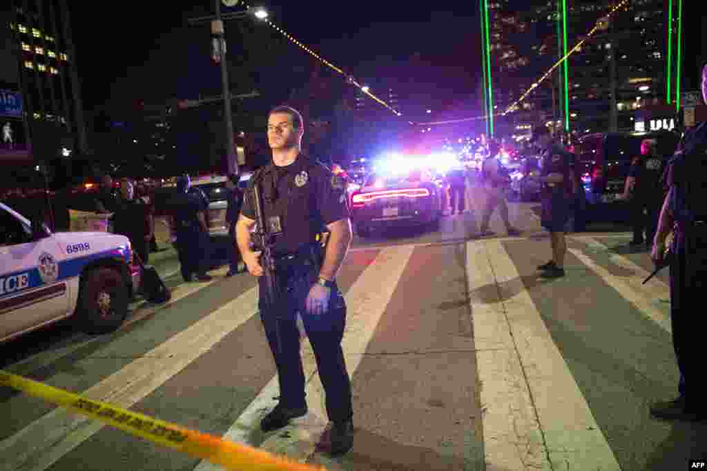 Police officers stand guard at a baracade following the sniper shooting in Dallas on July 7, 2016. 