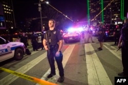FILE - Police officers stand guard at a baracade following the sniper shooting in Dallas on July 7, 2016.