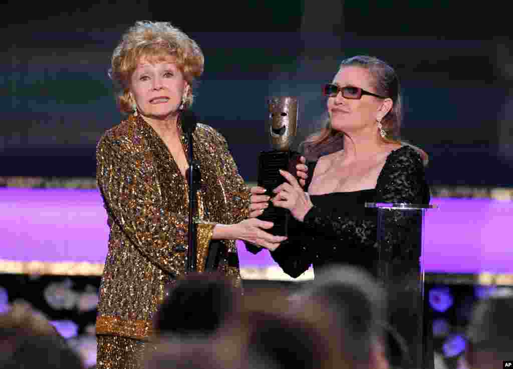 Carrie Fisher entrega a su mamá Debbie Reynolds el reconocimiento por toda una vida de logros de la Asociación de Actores Cinematográficos, en Los Ángeles, el 25 de enero de 2015.
