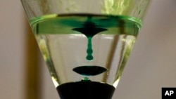 FILE - Liquid drops into a laboratory apparatus after the conversion of dihydroartemisinic acid to artemisinin at a laboratory at Berlin's Free University, in Berlin, Germany, Feb. 1, 2012. Artemisinin has been found to have the potential to shorten how long it takes to treat TB.
