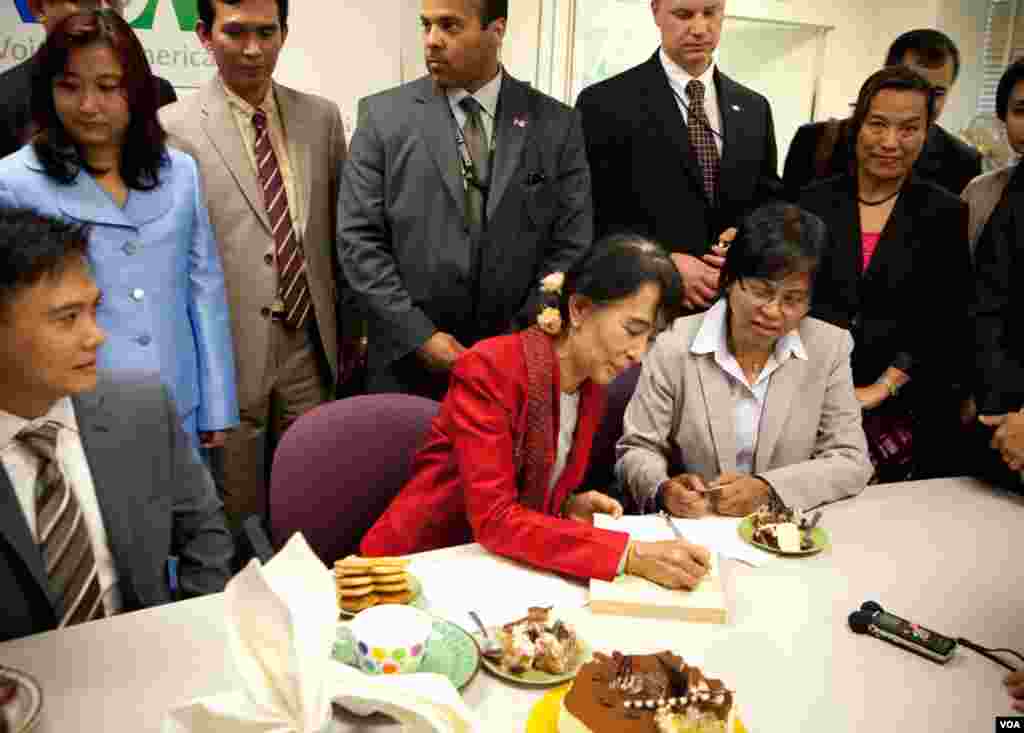 Journalists in VOA's Burmese service excitedly greet Suu Kyi as she visits their bureau. (Alison Klein/VOA)