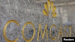 FILE - The NBC and Comcast logos are displayed on 30 Rockefeller Plaza in midtown Manhattan in New York.