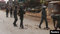 Des policiers anti-émeutes patrouillent dans une rue de Conakry après une manifestation, 7 mai 2015