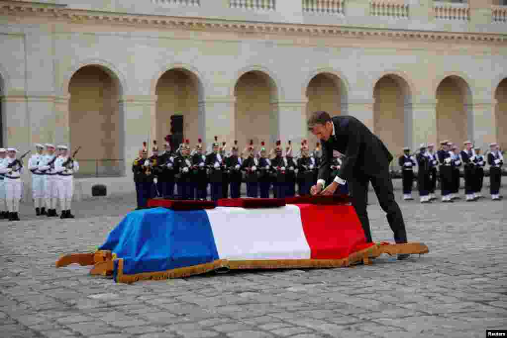 French President Emmanuel Macron honors the flag-drapped coffin of late Maxime Blasco, a French soldier killed in Mali militant clash, during a national ceremony at the Invalides in Paris.