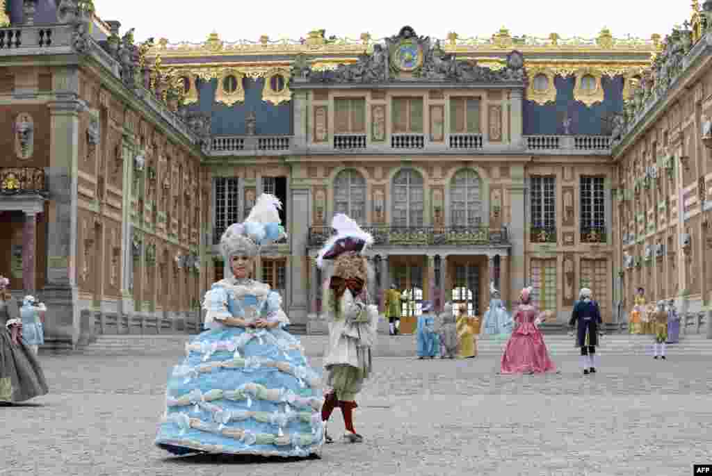 People dressed in period costumes pose for a photograph during the &quot;Fetes Galantes&quot; fancy dress evening in front of the Chateau de Versailles, in Versailles, France, May 28, 2018.