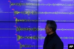 FILE - Yun Won-tae of the Korea Meteorological Administration stands in front of a screen showing seismic waves that were measured in Seoul after North Korea said it had conducted a powerful hydrogen bomb test, Dec. 6, 2015.