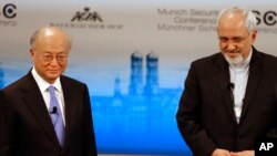 Iran's Foreign Minister Mohammad Javad Zarif, right, waits next to Director General of the International Atomic Energy Agency, IAEA, Yukiya Amano, for the start of a panel discussion at the 50th Security Conference on security policy in Munich, Germany, Feb. 2, 2014