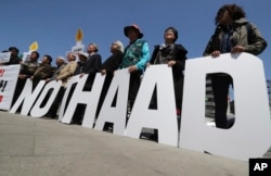 FILE - Protesters hold letters reading "NO THAAD" during a rally opposing the deployment of an advanced U.S. missile defense system called Terminal High-Altitude Area Defense, or THAAD, near the U.S. Embassy in Seoul, South Korea, April 26, 2017. The missile shield, experts predict, will likely become an added source of friction between Seoul and Washington.