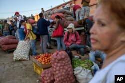 Vegetable vendors wait for customers at a wholesale food market in Caracas, Venezuela, Jan. 28, 2019.