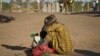 A South Sudanese refugee woman sits with her child at a refugee collection center in Palorinya, Uganda, Feb. 16, 2017.