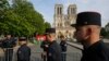Members of Paris Firefighters' brigade enter the security perimeter to Notre Dame cathedral in Paris, April 18, 2019. France paid a daylong tribute Thursday to the Paris firefighters who saved Notre Dame Cathedral from collapse.
