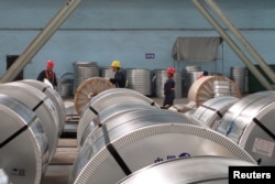 FILE - Workers pack cold rolled steel coil at a steel company in Zhangjiagang, Jiangsu province, China, April 27, 2018.