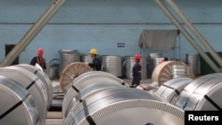 FILE - Workers pack cold rolled steel coil at a steel company in Zhangjiagang, Jiangsu province, China, April 27, 2018.