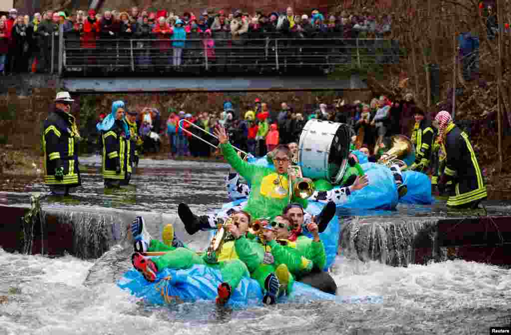 Carnival celebrators with self-made floats ride down the Schiltach stream during the &#39;Bach na fahre&#39; (race down the stream) raft contest in Schramberg, Germany.