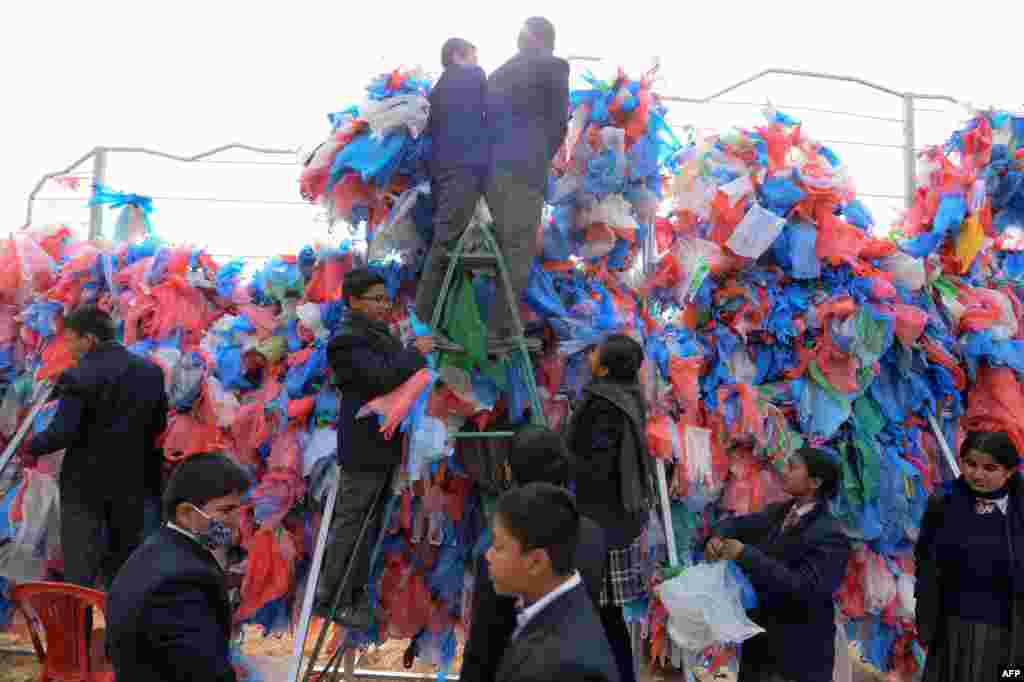 Nepali volunteers and school children tie together recycled plastic bags to make a sculpture representing the Dead Sea, in a bid to set a new world record for the largest sculpture made out of recycled plastic bags, in Kathmandu.