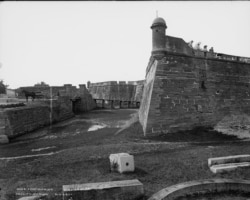 Tourists atop masonry wall look down on the water battery at Fort Marion, St. Augustine, Fla. Photo ca 1800-1897 by Wm. Henry Jackson.