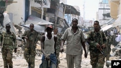 Somali government soldiers patrol a section of Bakara market following the demolition of illegal structures erected next to access roads in Mogadishu, April 30, 2012.