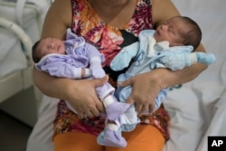 FILE - Severina Raimunda holds her granddaughter Melisa Vitoria, left, who was born with microcephaly and her twin brother, Edison Junior, at the IMIP hospital in Recife, Pernambuco state, Brazil, Feb. 3, 2016.