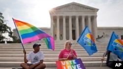 FILE - Same-sex marriage supporters gather outside of the Supreme Court in Washington, June 26, 2015. 