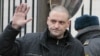 Russian opposition leader Sergei Udaltsov waves to the media before entering the Russian Investigative Committee's office in Moscow, Russia, Friday, Dec. 14, 2012.