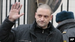 Russian opposition leader Sergei Udaltsov waves to the media before entering the Russian Investigative Committee's office in Moscow, Russia, Friday, Dec. 14, 2012.